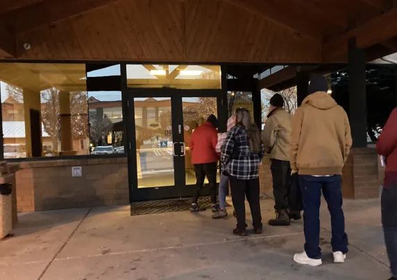 People standing in line outside a building