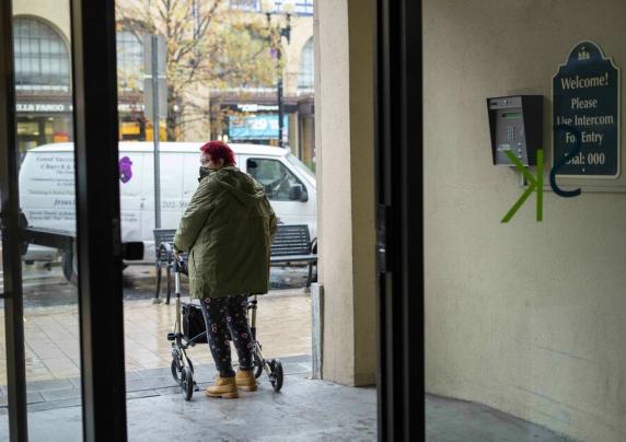 Woman exiting a building using a walker