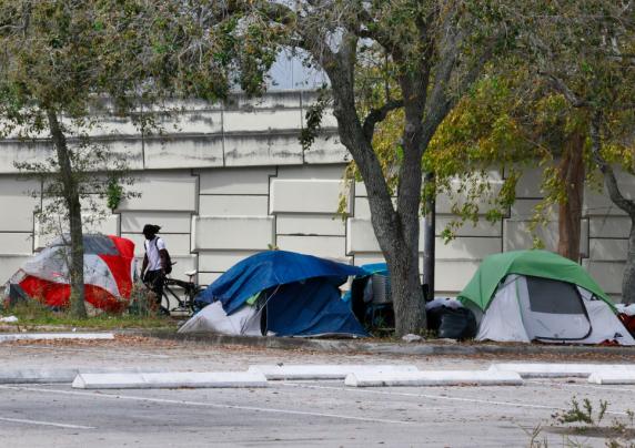 Tents and a person near a parking lot