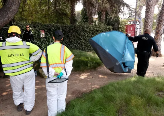 LA workers removing a tent from a public location