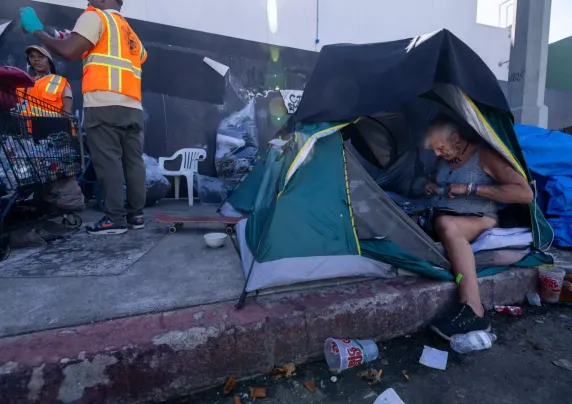 People and tents on sidewalk