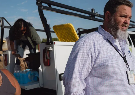 A man stands near a truck outdoors