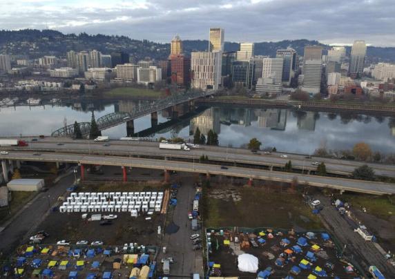 In this aerial photo, tents housing people experiencing homelessness are set up on a vacant parking lot in Portland, Ore., Dec. 8, 2020. (AP Photo/Craig Mitchelldyer, File)