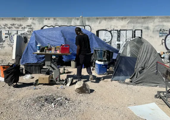 Photograph of a man and a tent outdoors