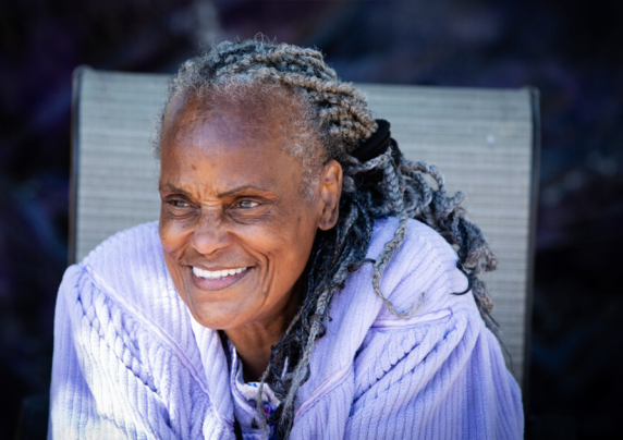 An older woman sitting outside.