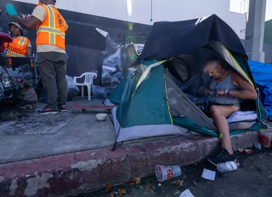 People and tents on sidewalk